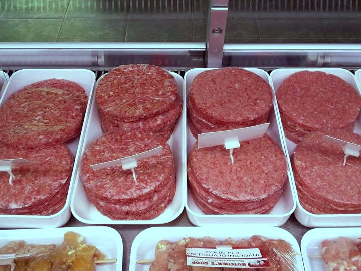 Hamburger di scottona crudi nel banco frigo