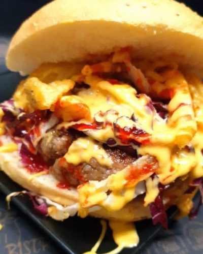 Un panino gourmet con hamburger, salse e verdure