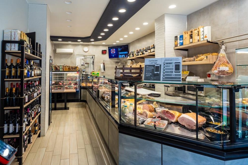 L'interno del negozio: il banco frigo della carne, la gastronomia e gli scaffali dei vini
